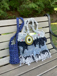 a crocheted bag sitting on a bench