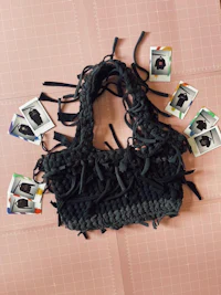 a black crocheted bag laying on top of a piece of paper