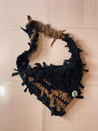 a black and brown crocheted bandana on a table