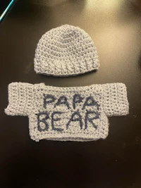 a crocheted hat with the words papa bear on it